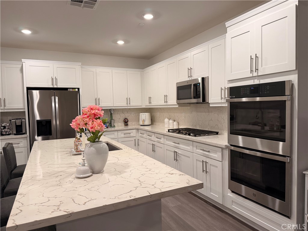 562 Hudson Way Rialto, CA 92377 - Photo 2 of 5 a kitchen with a stove a microwave and refrigerator