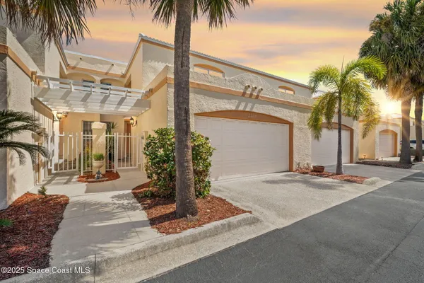a front view of a house with palm tree