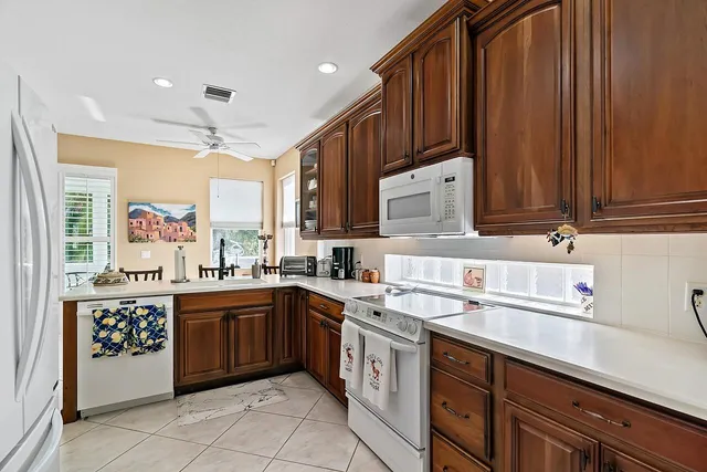 a kitchen with a dining table chairs and refrigerator