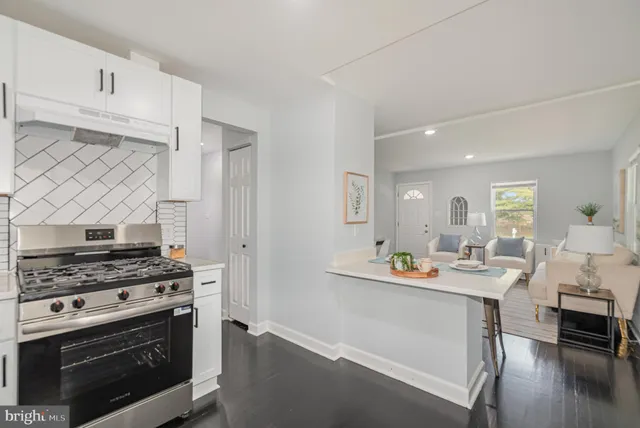 a kitchen with stainless steel appliances a stove a sink cabinets and a dining table