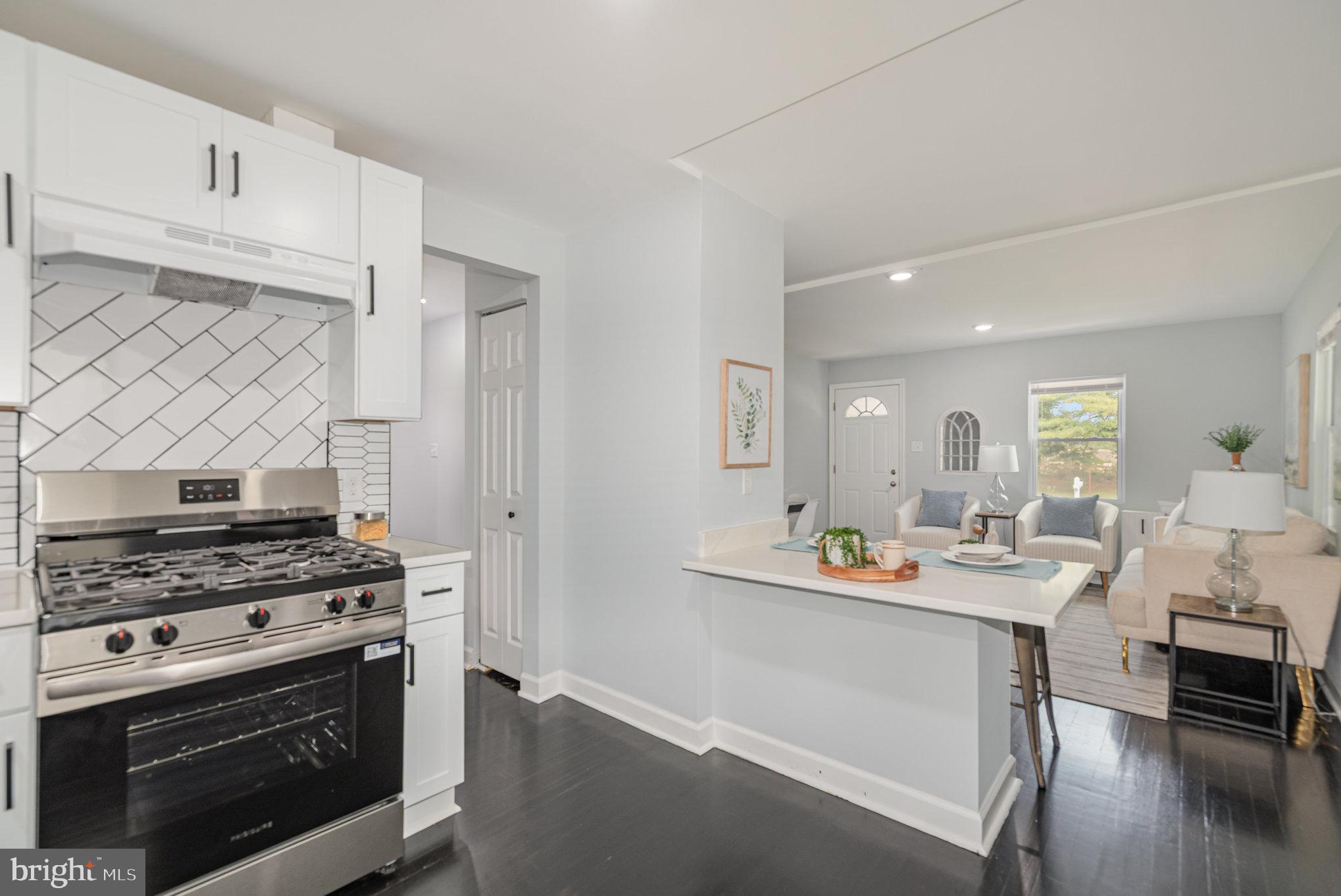 1205 North Point Road Dundalk, MD 21222 - Photo 11 of 19 a kitchen with stainless steel appliances a stove a sink cabinets and a dining table