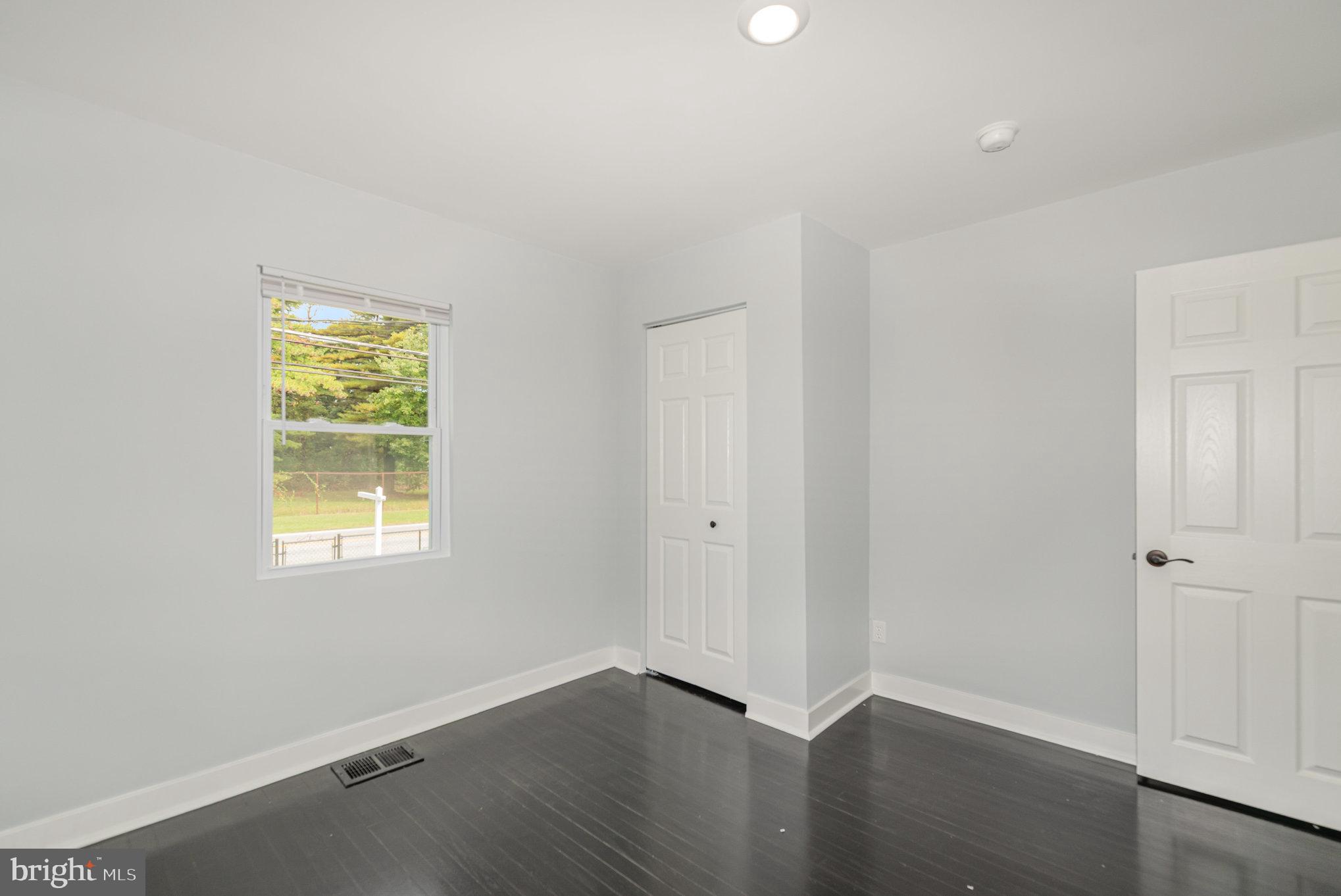 1205 North Point Road Dundalk, MD 21222 - Photo 17 of 19 an empty room with wooden floor and windows