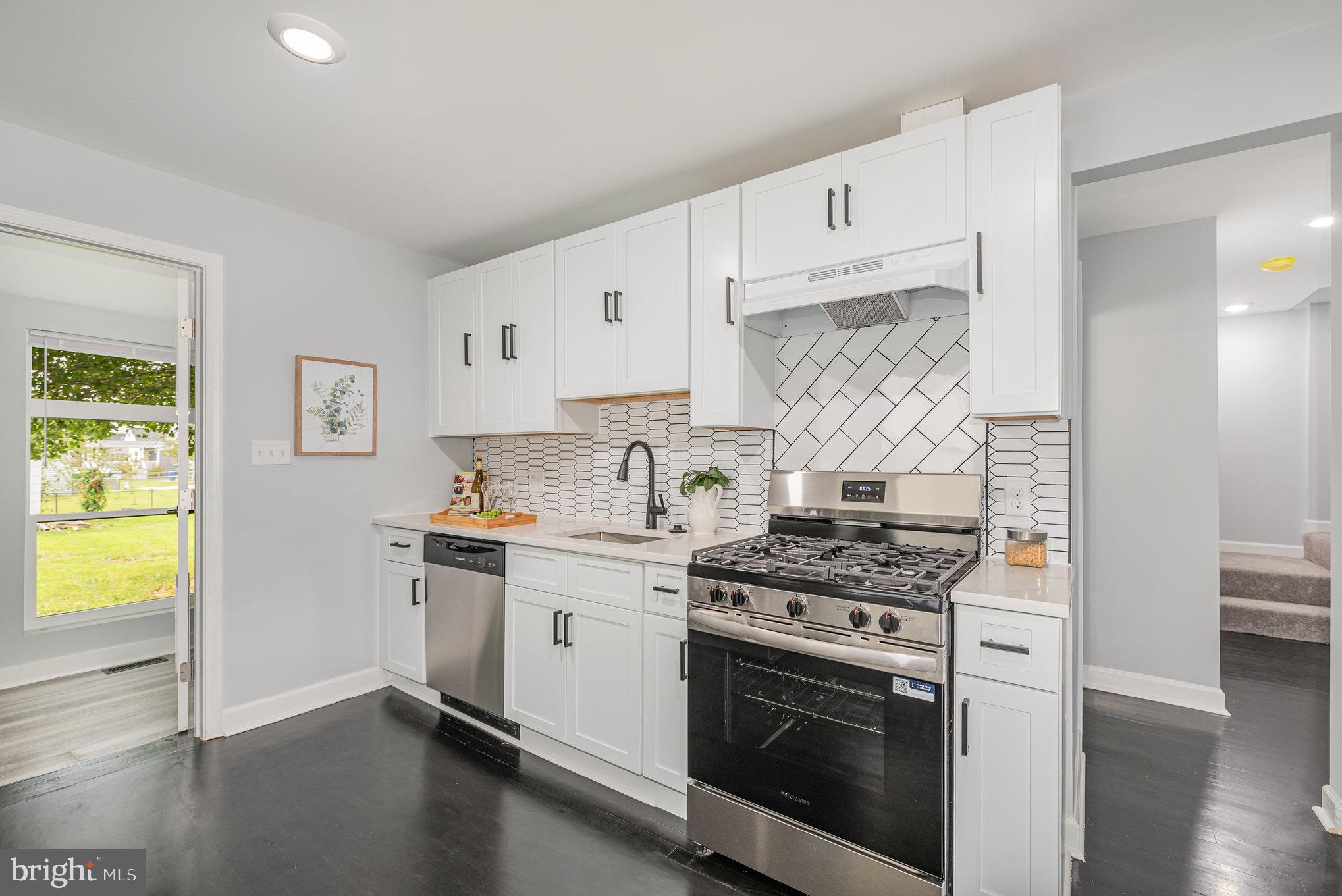 1205 North Point Road Dundalk, MD 21222 - Photo 10 of 19 a kitchen with stainless steel appliances white cabinets and a stove top oven