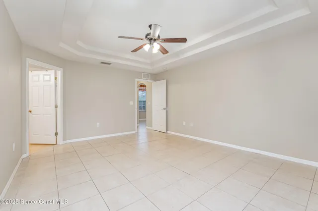 an empty room with fan and windows