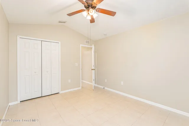 an empty room with a ceiling fan and a window
