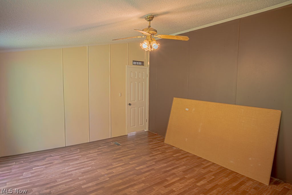 967 Buck Run Road Mineral Wells, WV 26150 - Photo 39 of 50 Room featuring a ceiling fan with light fixture, wood-finish flooring, and two-tone wall paneling