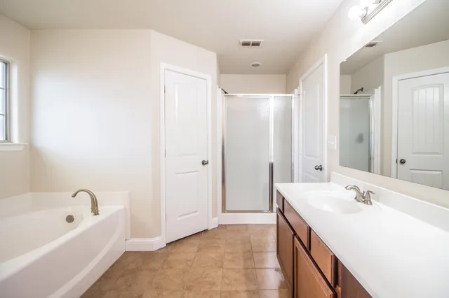 a bathroom with a tub sink and mirror