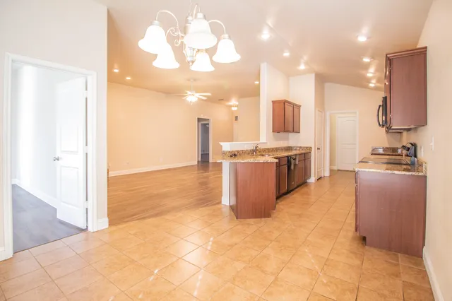 a kitchen with stainless steel appliances granite countertop a stove a sink and a refrigerator