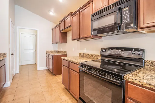 a kitchen with stainless steel appliances granite countertop a stove and a microwave