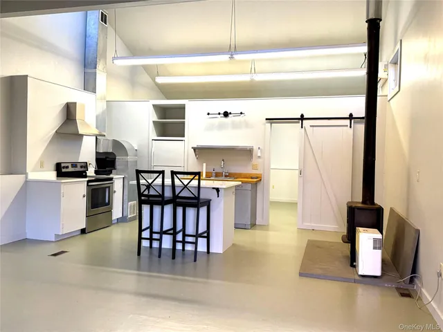 a kitchen with granite countertop a stove a refrigerator and a dining table