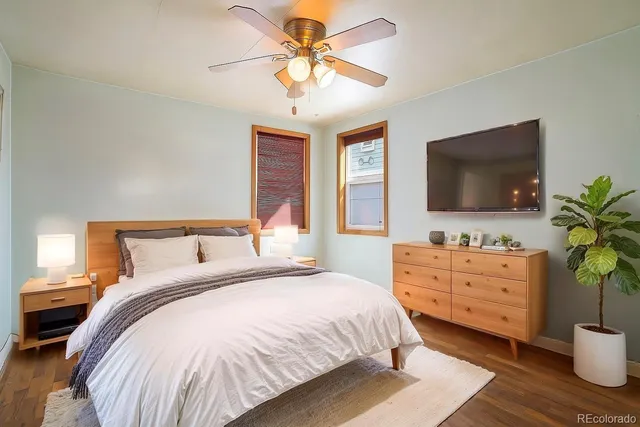 a spacious bedroom with a bed and a flat screen tv