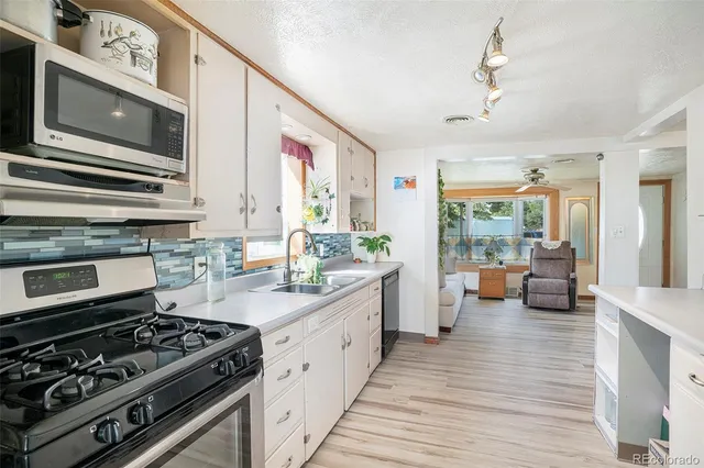 a kitchen with stainless steel appliances a stove cabinets and wooden floor