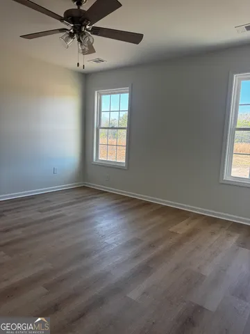a view of a room with a window and a ceiling fan
