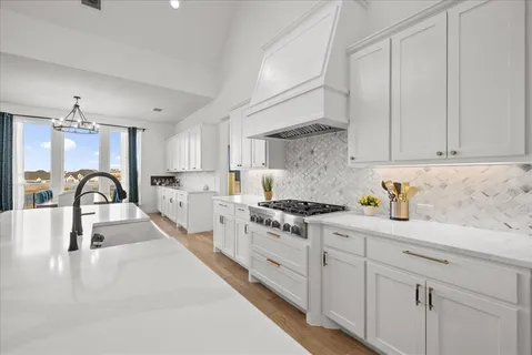 a kitchen with granite countertop a white stove top oven and cabinets