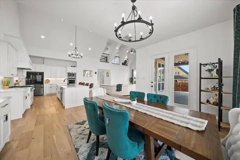 a dining room with stainless steel appliances kitchen island a table chairs and a kitchen view