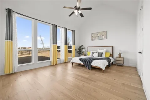 a spacious bedroom with a bed and glass walk in closet