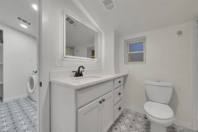 a bathroom with a toilet sink and mirror