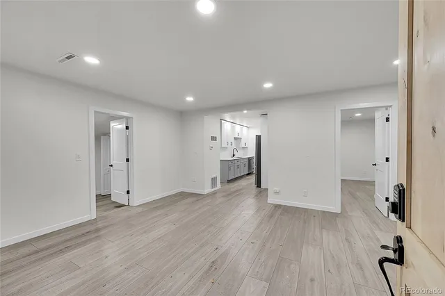 a view of empty room with wooden floor