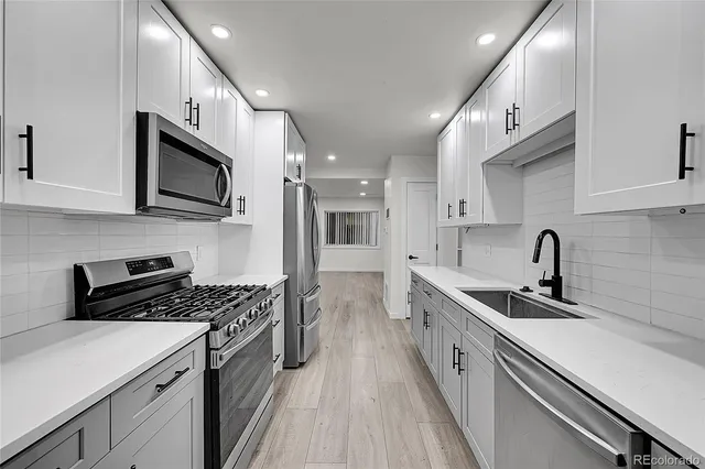 a kitchen with cabinets and stainless steel appliances