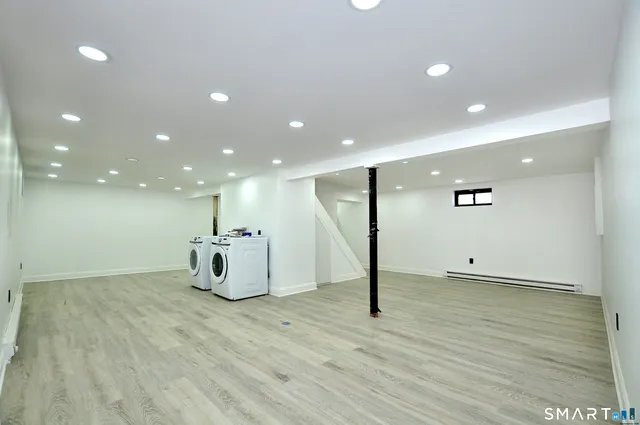 a view of an empty room with wooden floor and windows