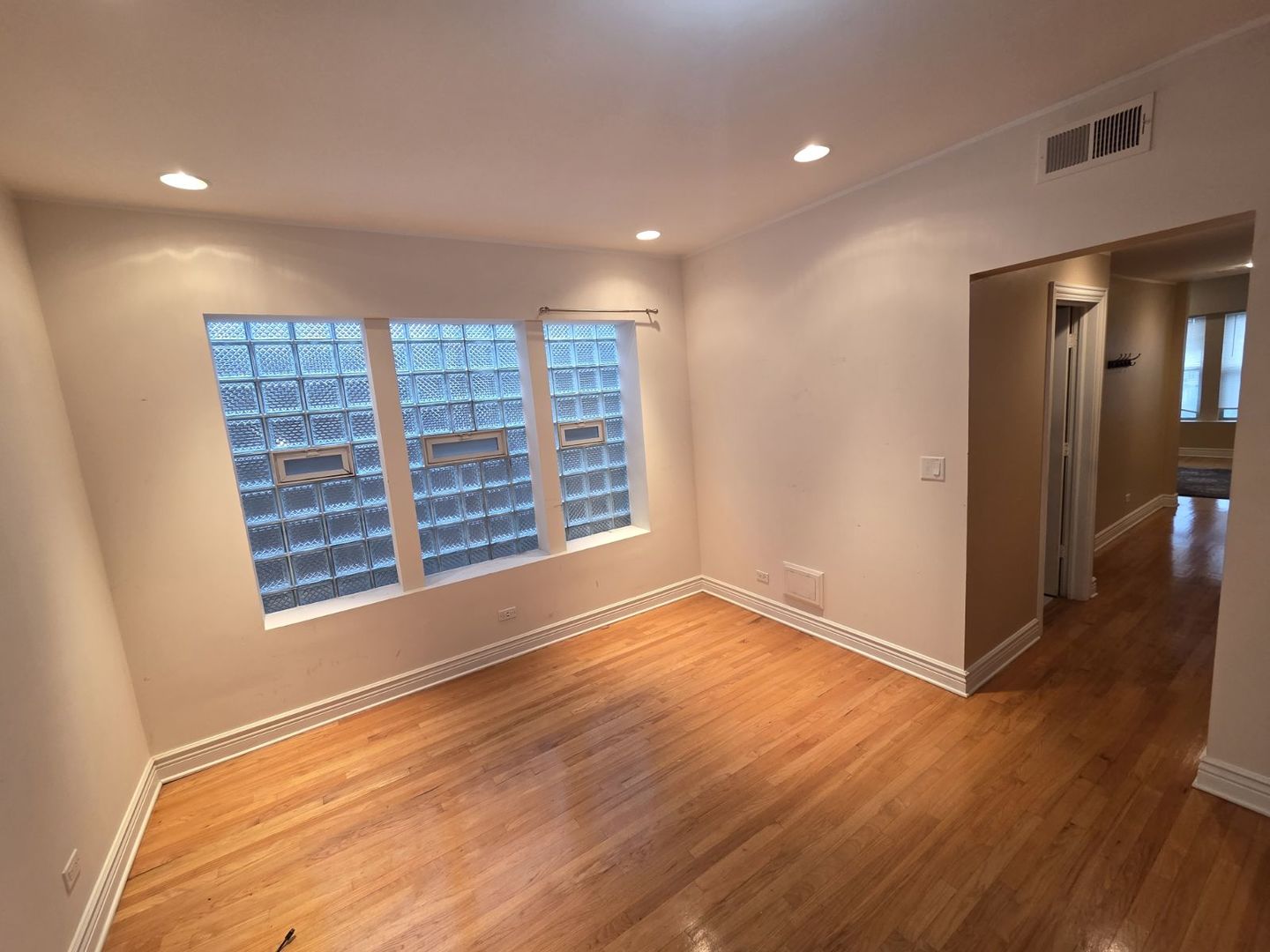 5902 West Madison Street, Unit 3 Chicago, IL 60644 - Photo 12 of 18 a view of an empty room with wooden floor and a window