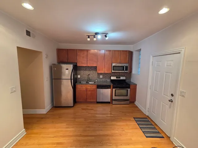 a kitchen with refrigerator cabinets and wooden floor