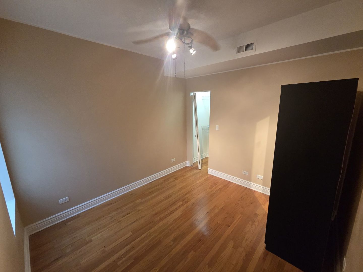 5902 West Madison Street, Unit 3 Chicago, IL 60644 - Photo 8 of 18 an empty room with wooden floor and windows