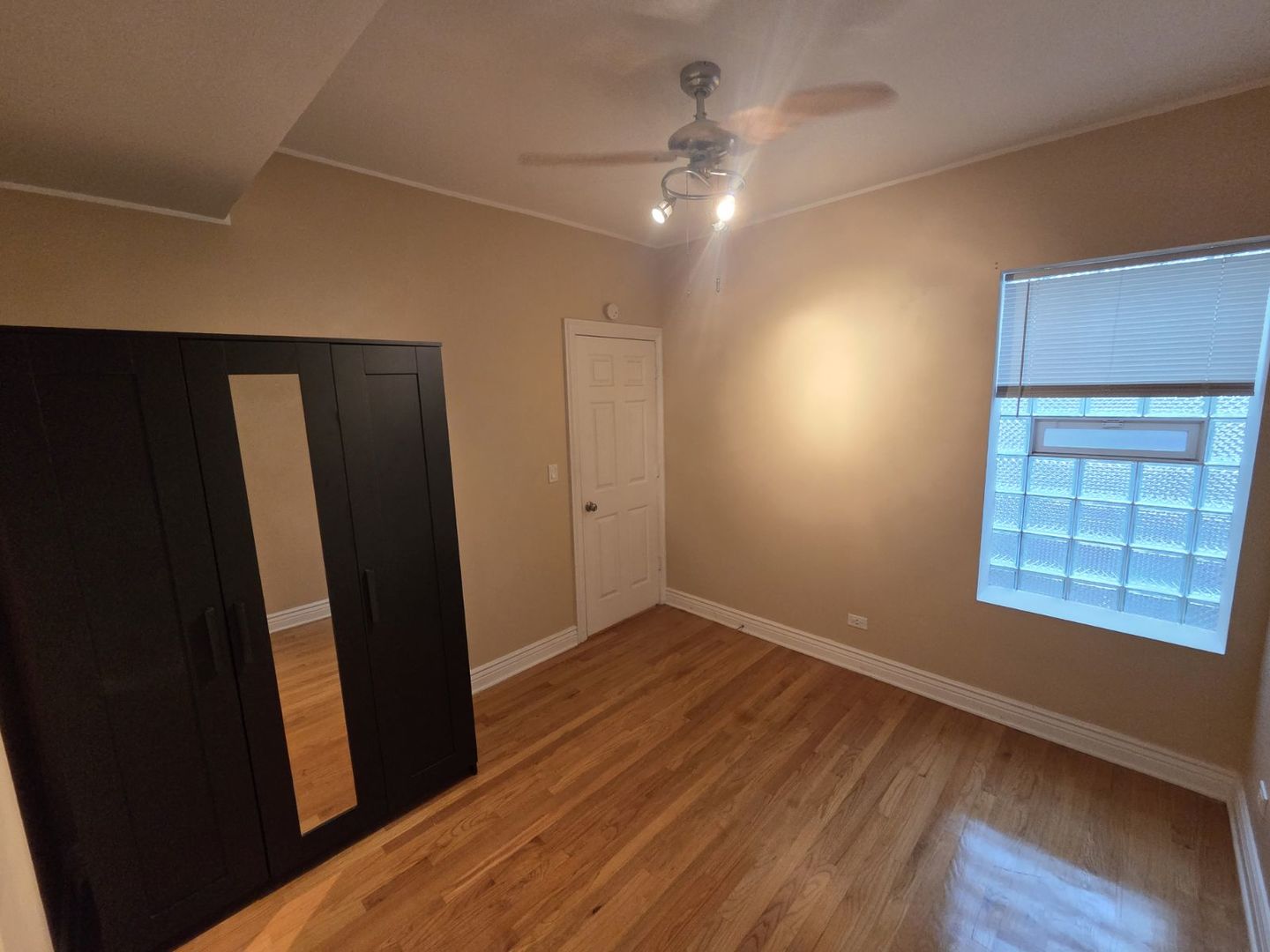5902 West Madison Street, Unit 3 Chicago, IL 60644 - Photo 9 of 18 an empty room with wooden floor and windows