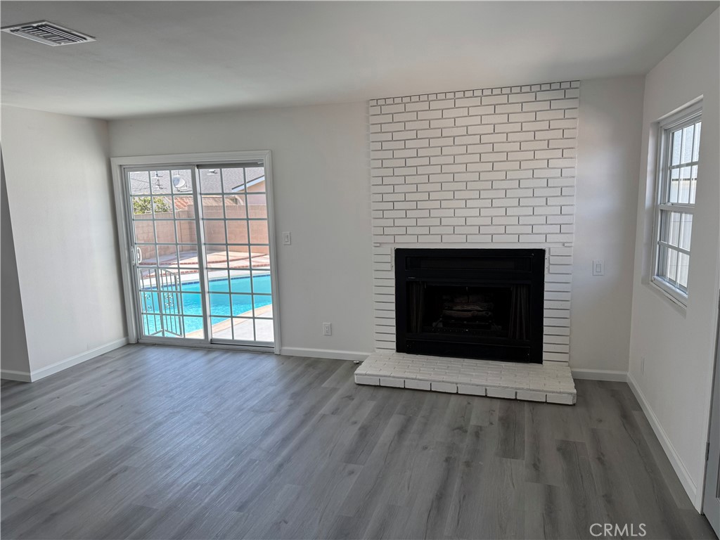 5781 Lime Avenue Cypress, CA 90630 - Photo 15 of 40 an empty room with wooden floor fireplace and windows