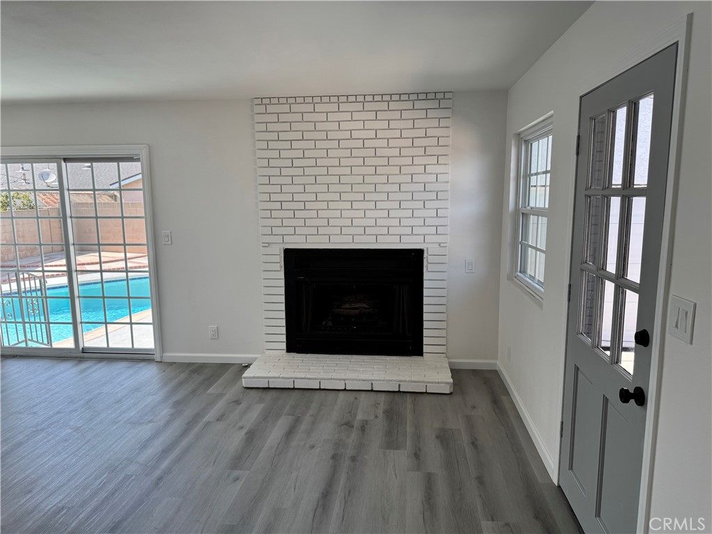 5781 Lime Avenue Cypress, CA 90630 - Photo 16 of 40 an empty room with wooden floor fireplace and windows