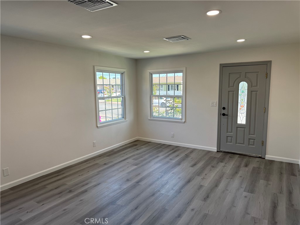 5781 Lime Avenue Cypress, CA 90630 - Photo 8 of 40 an empty room with wooden floor and windows