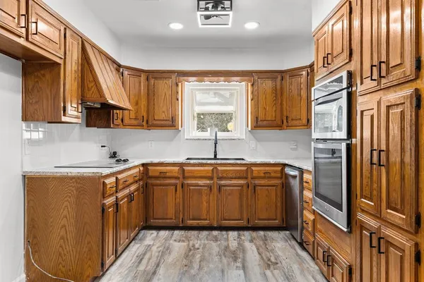 a kitchen with stainless steel appliances granite countertop a sink a stove and a refrigerator