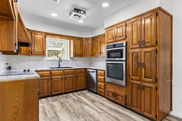 a kitchen with stainless steel appliances granite countertop a refrigerator and a sink