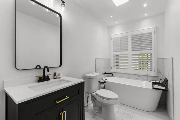 a bathroom with a sink a toilet and tub