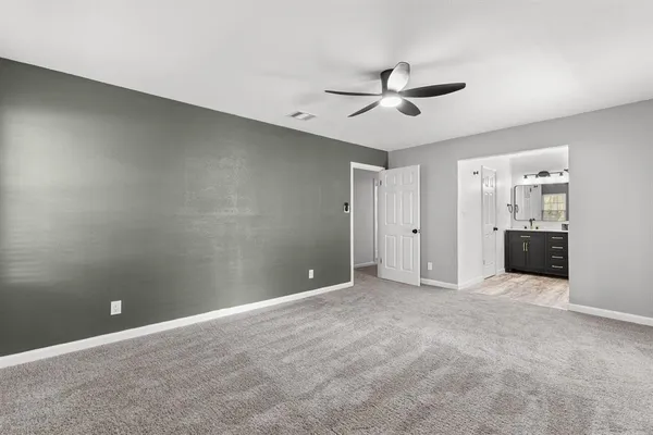 a view of an empty room with a ceiling fan