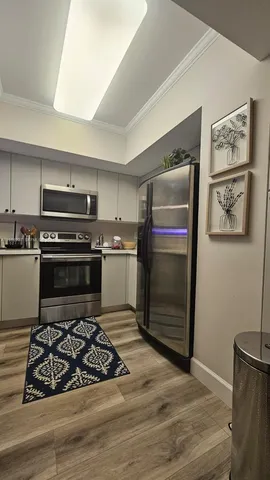 a bedroom with a bed and a flat tv screen on a dresser