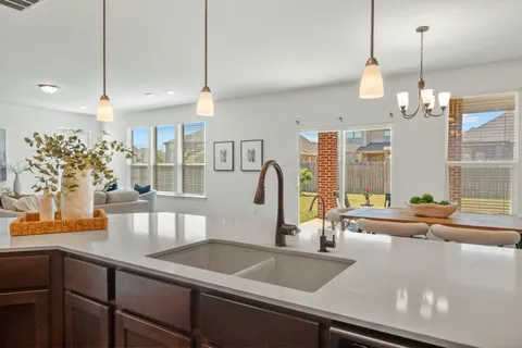 a view of a kitchen with kitchen island a large counter top space a sink and living room view