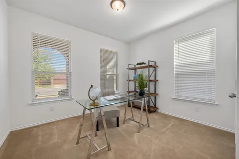 a view of a workspace with furniture and a window