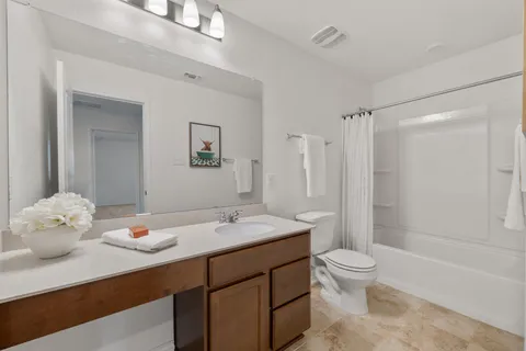 a bathroom with a double vanity sink toilet and shower