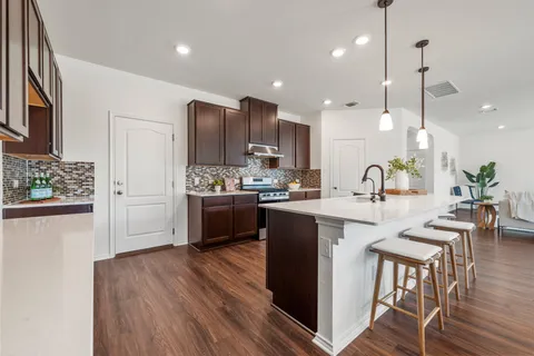 a kitchen with stainless steel appliances kitchen island granite countertop counter space a sink and a refrigerator