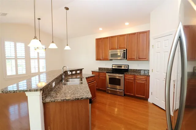 a kitchen with a refrigerator and a stove top oven