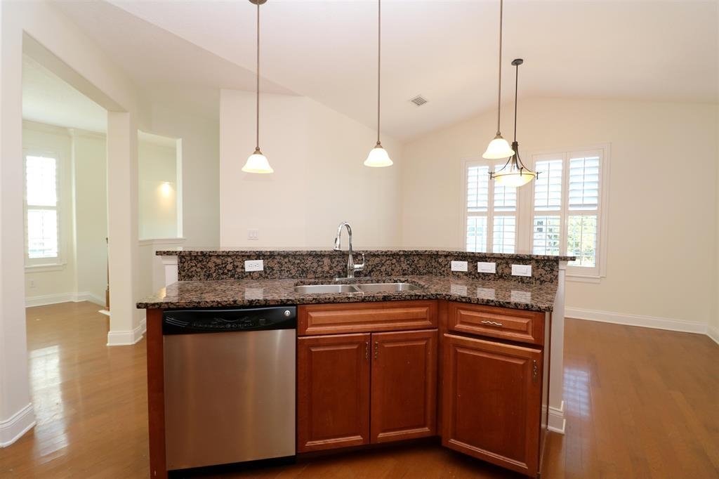 207 Sunset Point St. Augustine, FL 32080 - Photo 30 of 59 a kitchen with granite countertop a stove a sink and a wooden floors