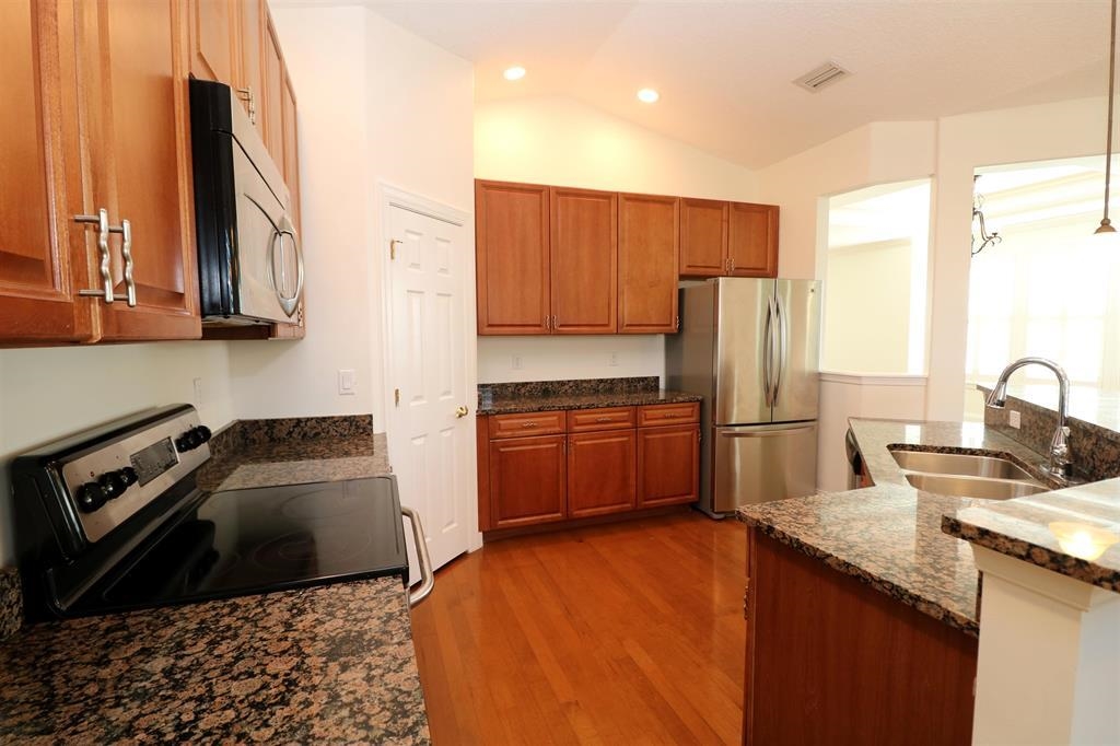 207 Sunset Point St. Augustine, FL 32080 - Photo 31 of 59 a kitchen with a sink a refrigerator and trees
