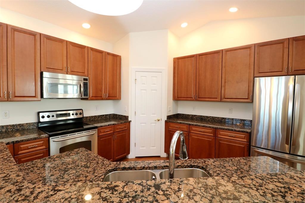 207 Sunset Point St. Augustine, FL 32080 - Photo 32 of 59 a kitchen with stainless steel appliances granite countertop a stove a sink and a microwave