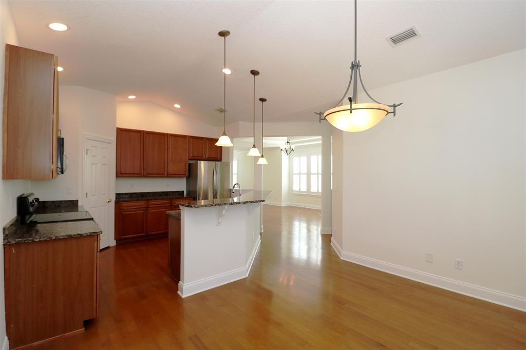 207 Sunset Point St. Augustine, FL 32080 - Photo 34 of 59 a kitchen with stainless steel appliances granite countertop a refrigerator a stove and a wooden floors