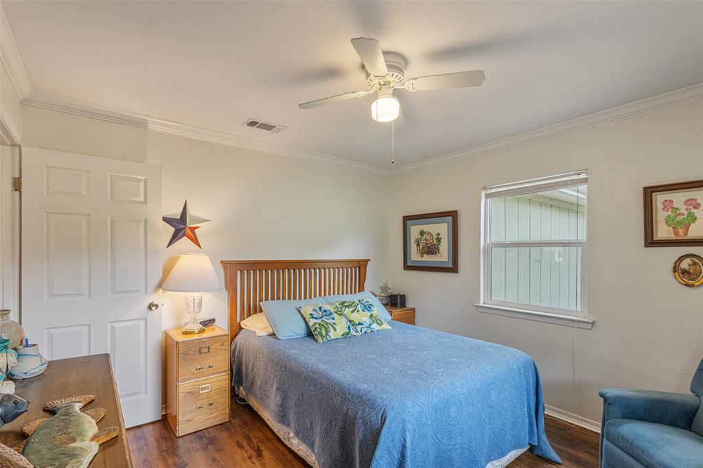 713 Midway Road Tool, TX 75143 - Photo 11 of 28 a bedroom with a bed and wooden floor