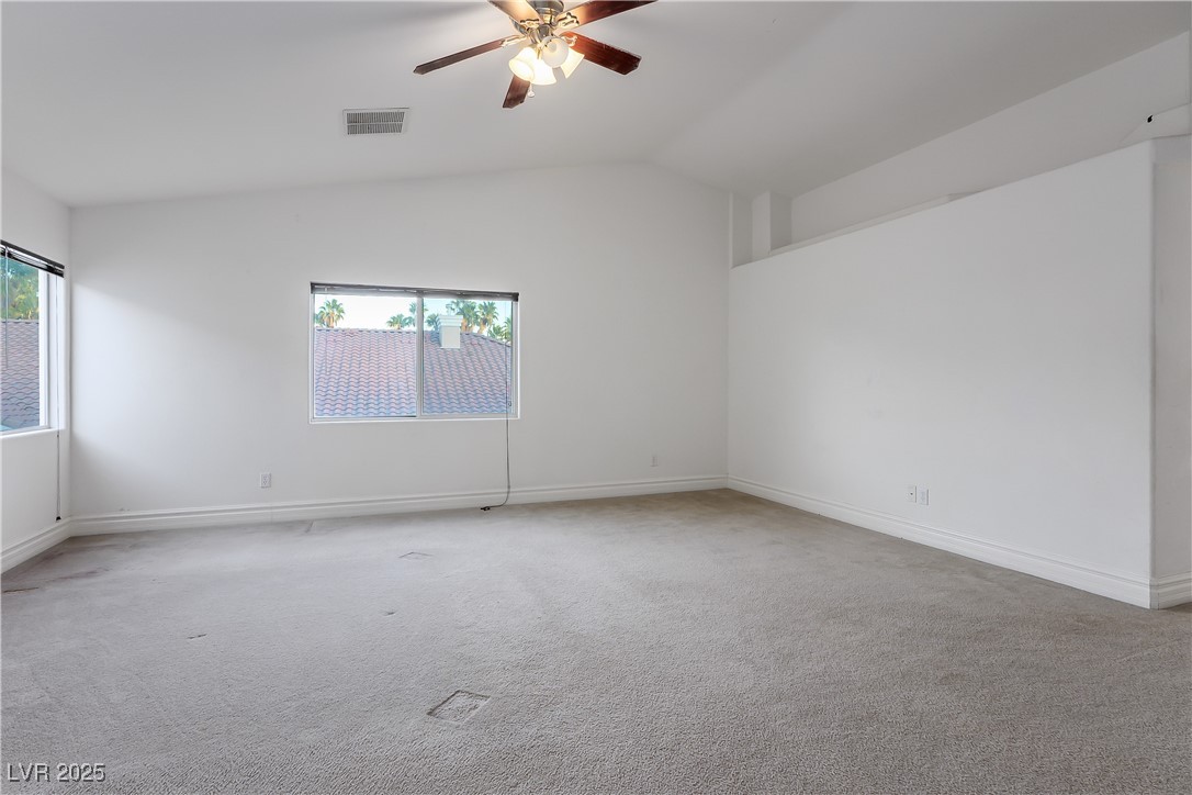 6632 Babys Tear Place Las Vegas, NV 89148 - Photo 18 of 27 Unfurnished room with carpet flooring, vaulted ceiling, and ceiling fan