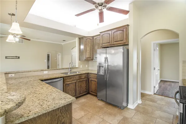 a kitchen with stainless steel appliances granite countertop a refrigerator and a sink