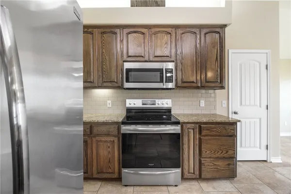 a kitchen with granite countertop a stove and a microwave