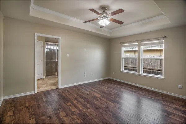 an empty room with wooden floor and window